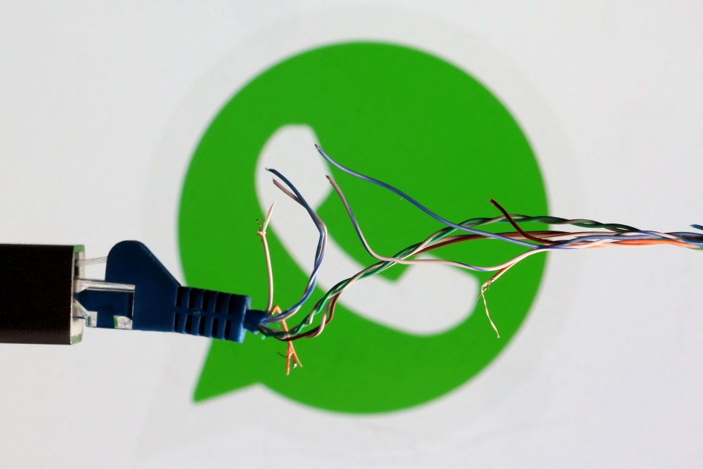 Broken Ethernet cable is seen in front of WhatsApp logo in this illustration taken March 11, 2022. (REUTERS/Dado Ruvic)