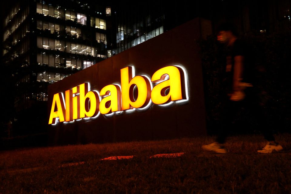 A man walks past a logo of Alibaba Group at its office building in Beijing, China August 9, 2021. REUTERS/Tingshu Wang/

