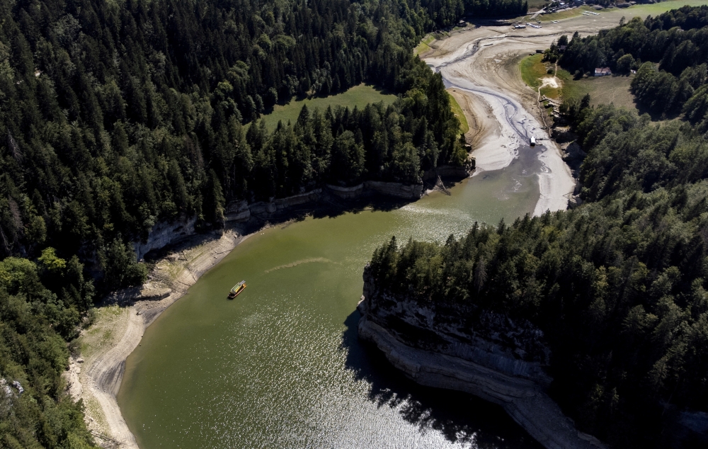 A tourist boat sails back at the end of the Doubs canyon on the drought-affected Doubs River on the border with France in Les Brenets, Switzerland, August 8, 2022. REUTERS/Denis Balibous