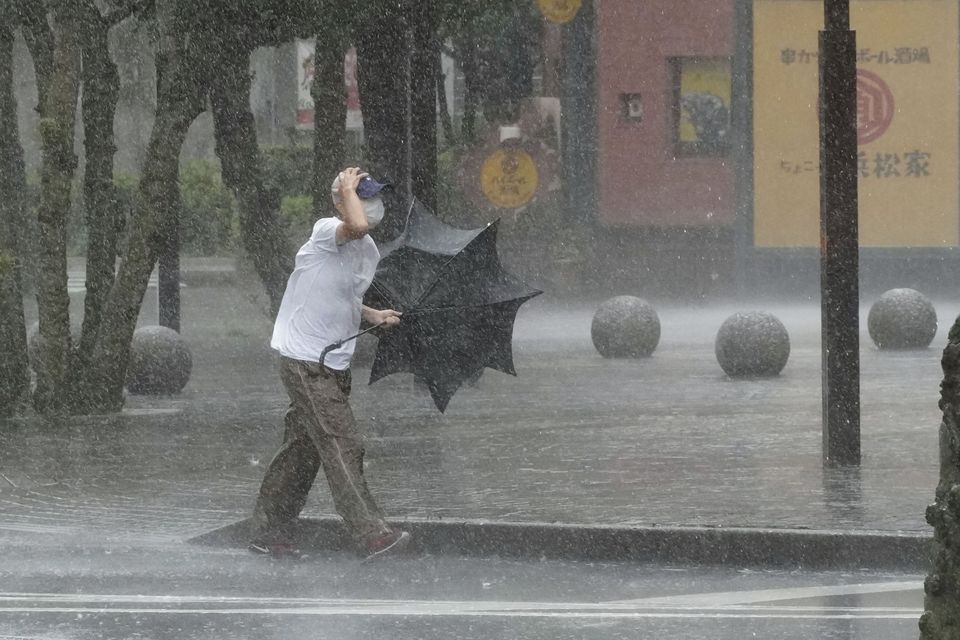 A man walks on the street in the heavy rain caused by Tropical Storm Meari in Hamamatsu, central Japan August 13, 2022, in this photo taken by Kyodo. Mandatory credit Kyodo via REUTERS
