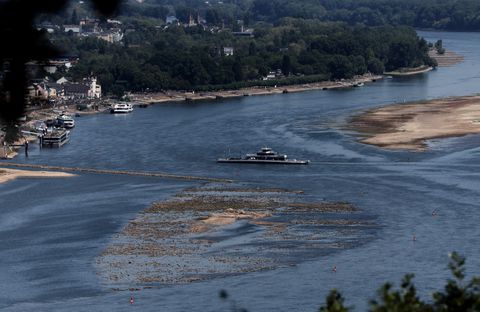 A ferry cruises past the partially dried riverbed of the Rhine river in Bingen, Germany, August 9, 2022. REUTERS/Wolfgang Rattay