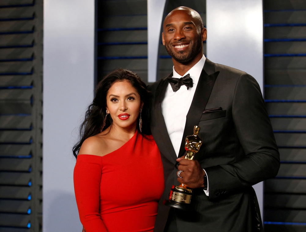 Kobe Bryant holds his Oscar for Best Animated Short, with wife Vanessa. REUTERS/Danny Moloshok/File Photo
