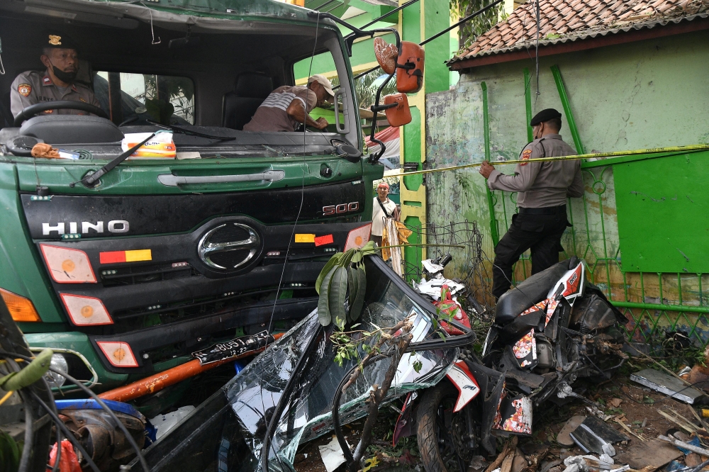 Police officers try to move a damaged truck after an accident in Bekasi, on the outskirts of Jakarta, Indonesia, August 31, 2022, in this photo taken by Antara Foto. Antara Foto/Fakhri Hermansyah/ via REUTERS