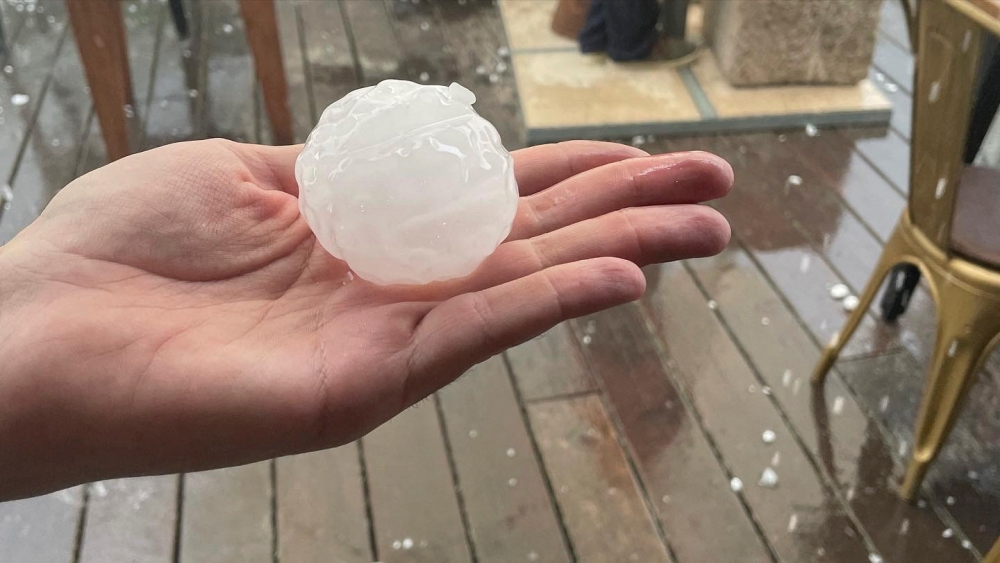 A person holds up a hailstone during a hailstorm in Girona, Spain August 30, 2022. Sicus Carbonell via Reuters 