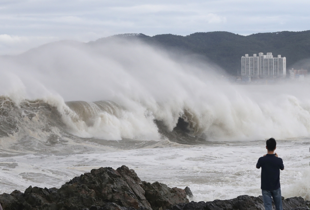 A man looks at a high wave caused by Typhoon Hinnamnor in Ulsan, South Korea, September 6, 2022. 
