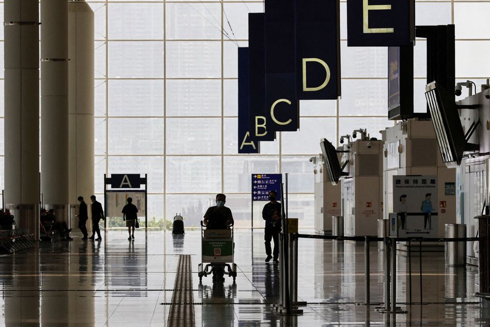 A traveller walks in the departure hall at the Hong Kong International Airport amid the coronavirus disease (COVID-19) pandemic in Hong Kong, China, March 21, 2022. REUTERS/Tyrone Siu/File Photo

