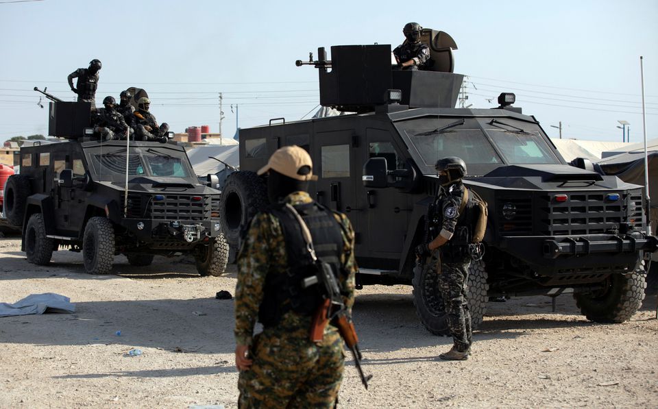 A Syrian Democratic Forces fighter stands near Kurdish internal security special forces during a security operation in al-Hol camp which holds displaced people and families of Islamic State fighters, in Hasaka governorate, in northeast Syria, on August 26, 2022. REUTERS/Orhan Qereman