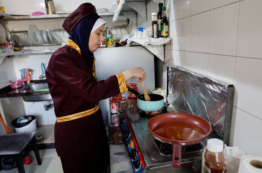 Palestinian chef Amena Al-Hayek cooks a meal at the newly-opened women-only restaurant, called Sabaia VIP, in Gaza City on September 6, 2022. Reuters/Mohammed Salem