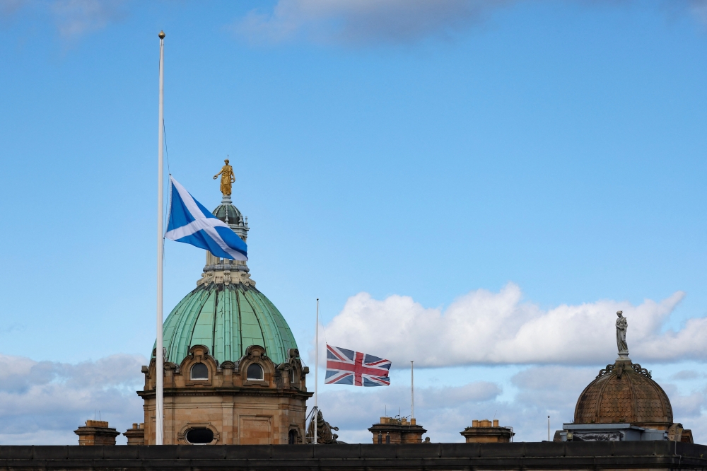 A Scottish flag and a Union Jack fly at half mast following the death of Britain's Queen Elizabeth, in Edinburgh, Scotland, Britain, on September 12, 2022. (REUTERS/Russell Cheyne)