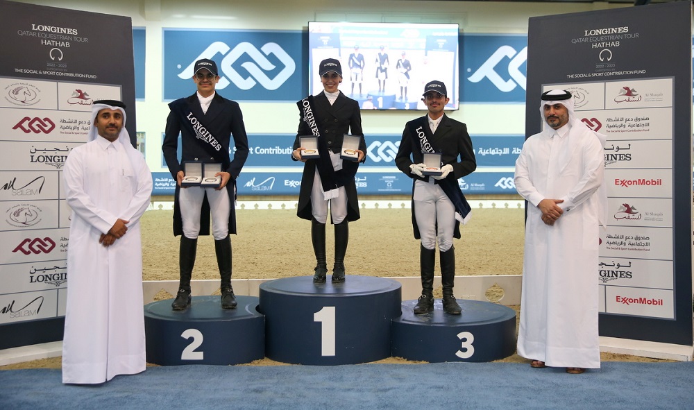 Maryam Ahmad Al Boinin (centre) poses on the podium with riders and officials. 