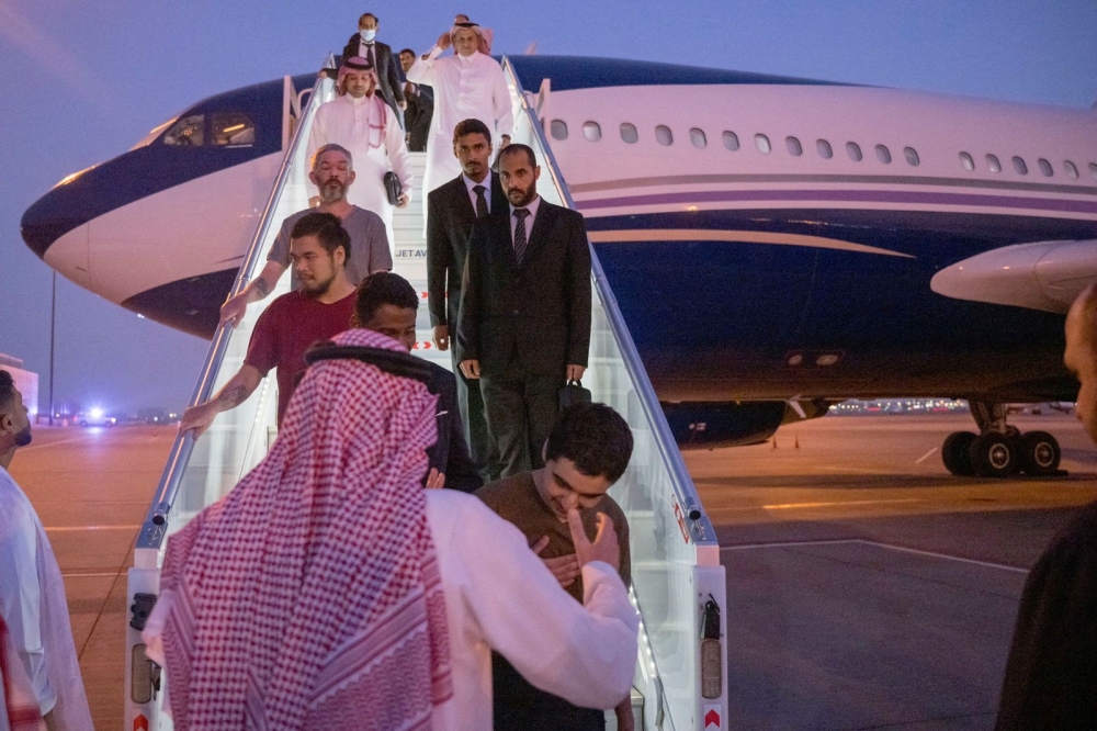 10 prisoners of war (five British citizens, one Moroccan, one Swedish, one Croatian, and two Americans) are seen arriving, following successful mediation efforts by Saudi Arabia's Crown Prince Mohammed bin Salman, from Russia to King Khalid International Airport, in Riyadh, Saudi Arabia, on September 21, 2022.  Saudi Press Agency/Handout via REUTERS