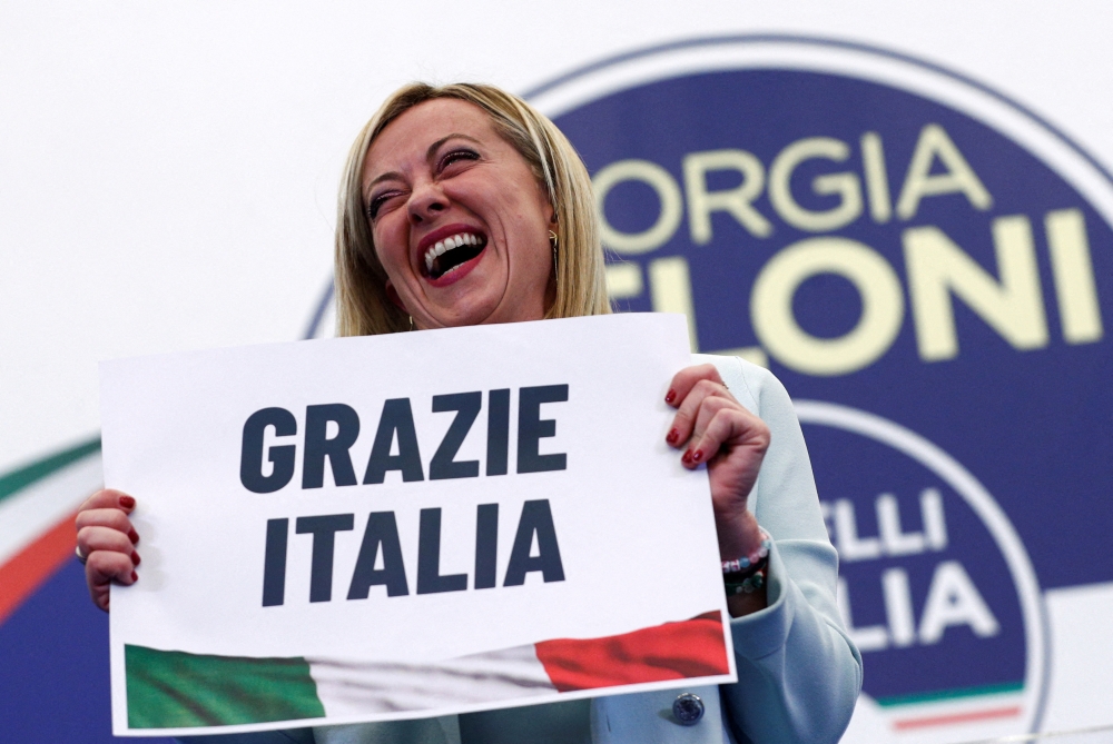 Leader of Brothers of Italy Giorgia Meloni holds a sign at the party's election night headquarters, in Rome, Italy September 26, 2022. REUTERS/Guglielmo Mangiapane 