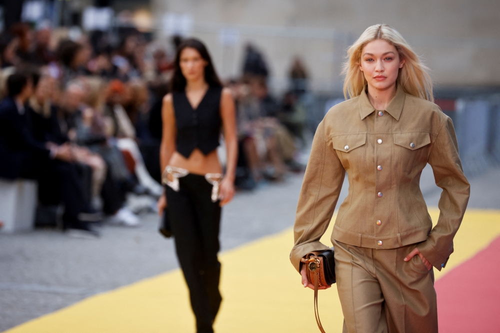 Models Bella Hadid and Gigi Hadid present creations by designer Stella McCartney as part of her Spring-Summer 2023 Women's ready-to-wear collection show during Paris Fashion Week in Paris, France, on October 3, 2022. (REUTERS/Johanna Geron)