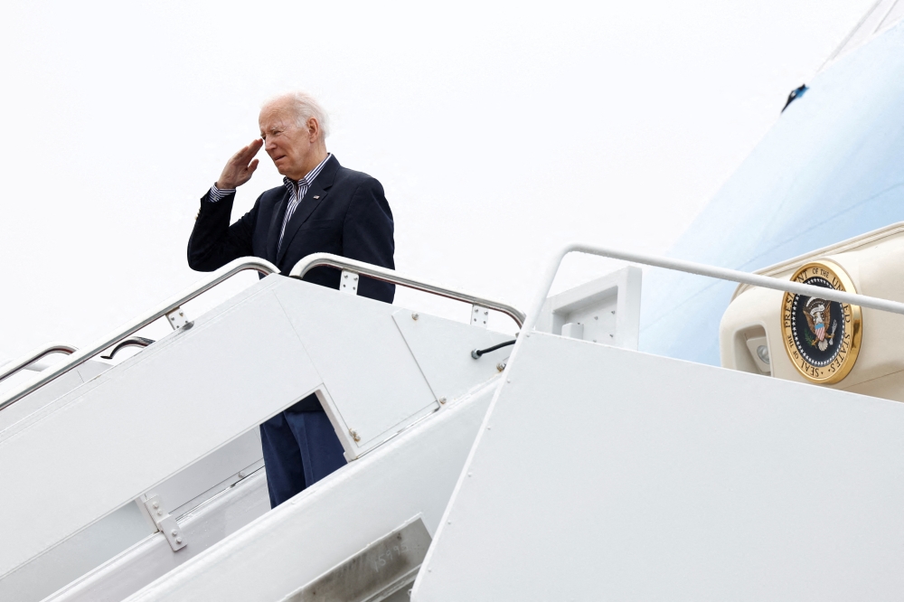 U.S. President Joe Biden salutes as he boards Air Force One upon departure for Florida from Joint Base Andrews in Maryland, U.S., October 5, 2022. REUTERS/Evelyn