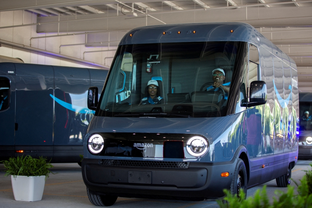 A new Amazon EV van powered by Rivian is driven past spectators at the Amazon Logistics Facility in Chicago, Illinois, US, July 21, 2022. (REUTERS/Jim Vondruska)