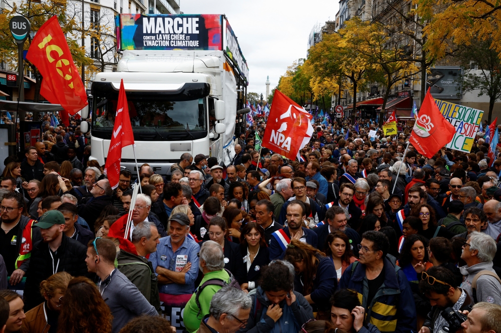 Demonstrators take part in a protest by New Ecologic and Social People's Union (NUPES), a coalition of left and green parties, against soaring inflation and what they call a lack of government action to fight climate change, in Paris, France, on October 16, 2022. REUTERS/Stephane Mahe