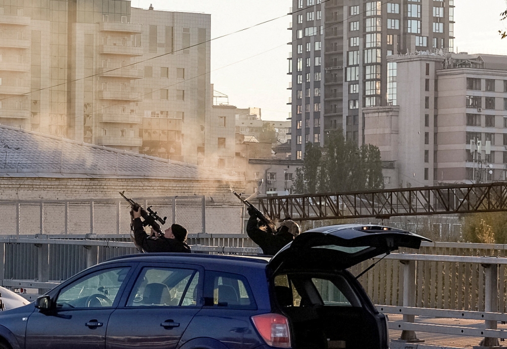 Police officers shoot at a drone during a Russian drone strike, which local authorities consider to be Iranian-made Shahed-136 unmanned aerial vehicles (UAVs), amid Russia's attack on Ukraine, in Kyiv, Ukraine, on October 17, 2022. REUTERS/Vadim Sarakhan
