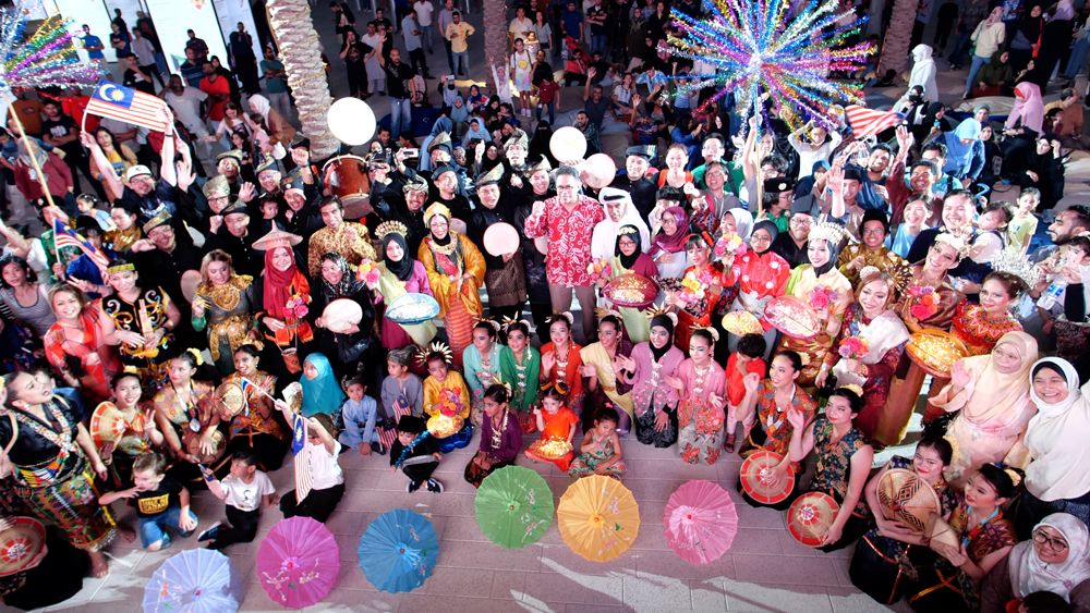 People in traditional clothes attend a performance at Flag Plaza. 