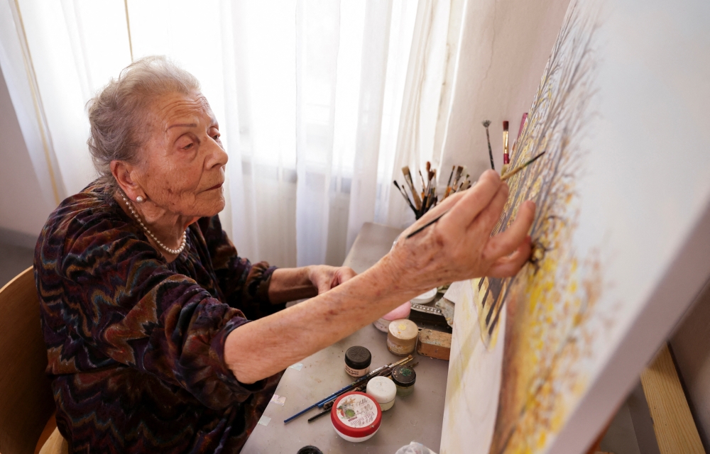 Nada Rudan, a 100-year-old self-taught Bosnian painter, paints in her home, in Sarajevo, Bosnia and Herzegovina, October 20, 2022. REUTERS/Dado Ruvic