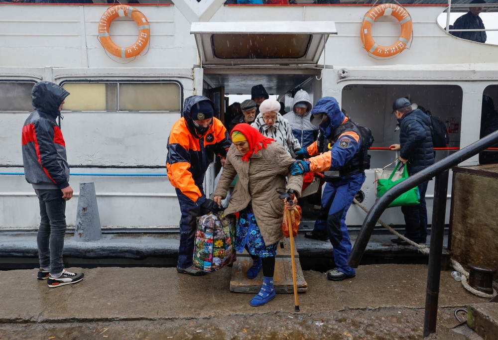 Civilians evacuated from the Russian-controlled city of Kherson walk from a ferry to board a bus heading to Crimea, in the town of Oleshky, Kherson region, Russian-controlled Ukraine, on October 23, 2022. REUTERS/Alexander Ermochenko