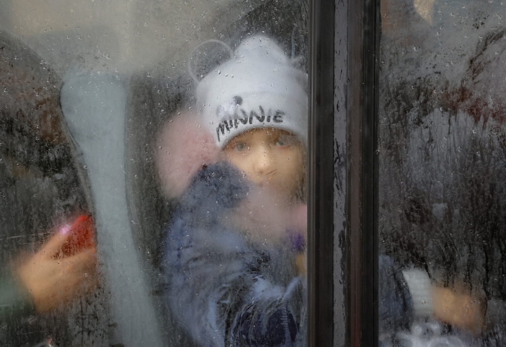 A boy evacuated from the Russian-controlled city of Kherson looks on in a bus heading to Crimea, in the town of Oleshky, Kherson region, Russian-controlled Ukraine October 23, 2022. (REUTERS/Alexander Ermochenko)