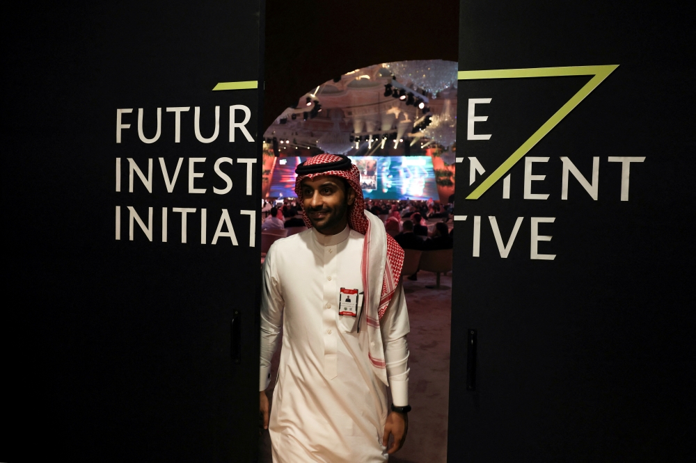 A Saudi man's reflection is seen in mirror glass at the Future Investment Initiative conference, in Riyadh, Saudi Arabia, on October 25, 2022. REUTERS/ Ahmed Yosri