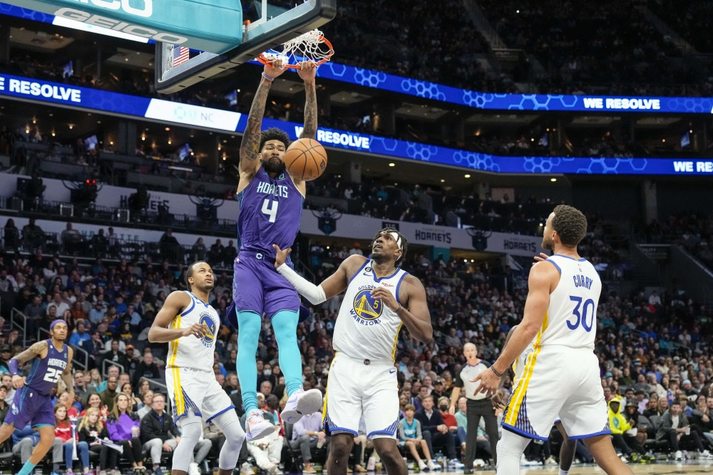 Charlotte Hornets center Nick Richards (4) gets a dunk over Golden State Warriors center Kevon Looney (5) during the second half at Spectrum Center. Jim Dedmon