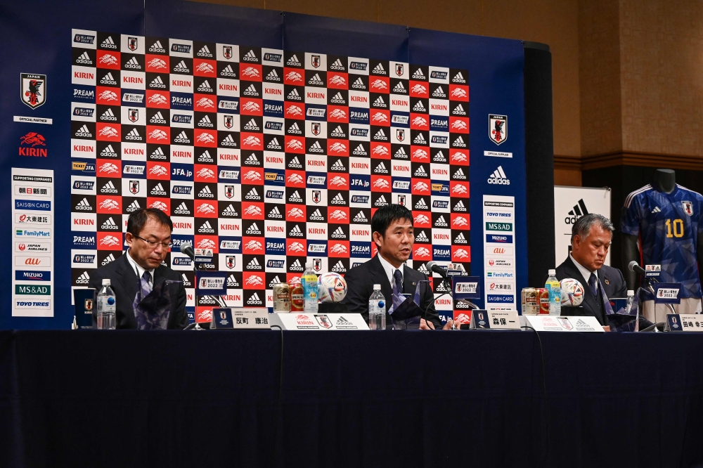 Japan's national football team manager Hajime Moriyasu (centre) speaks as Japan Football Association chairman Kozo Tashima (right) and JFA technical coach Yasuharu Sorimachi listen on during a press conference to officially announce the members of Japan's 2022 World Cup squad headed to Qatar, in Tokyo on November 1, 2022. (Photo by Richard A. Brooks / AFP)