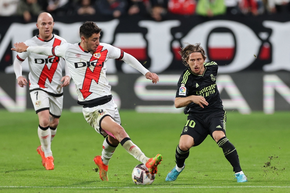 Real Madrid's Croatian midfielder Luka Modric (R) fights for the ball with Rayo Vallecano's Spanish midfielder Santi Comesana during the Spanish league football match between Rayo Vallecano de Madrid and Real Madrid CF at the Vallecas Stadium in the Madrid district of Puente de Vallecas on November 7, 2022. (Photo by Pierre-Philippe Marcou / AFP)