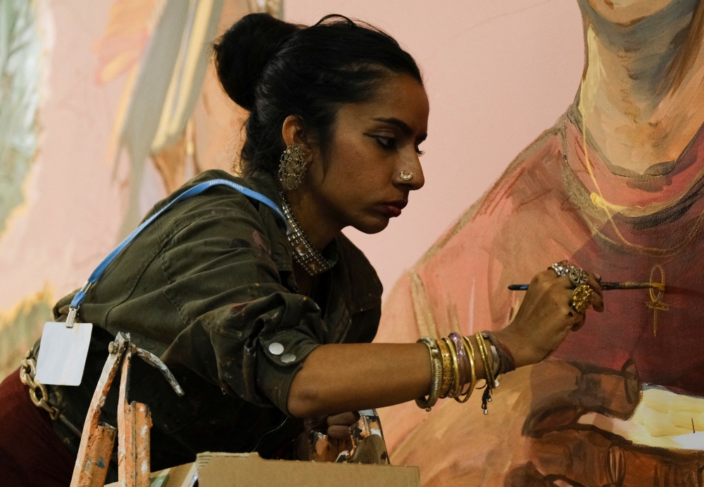 Shilo Shiv Suleman of India, founder of Fearless Collective, paints on a wall at the Children and Youth Pavilion during the COP27 climate summit in Red Sea resort at Sharm el-Sheikh, Egypt, on November 12, 2022. REUTERS/Emilie Madi