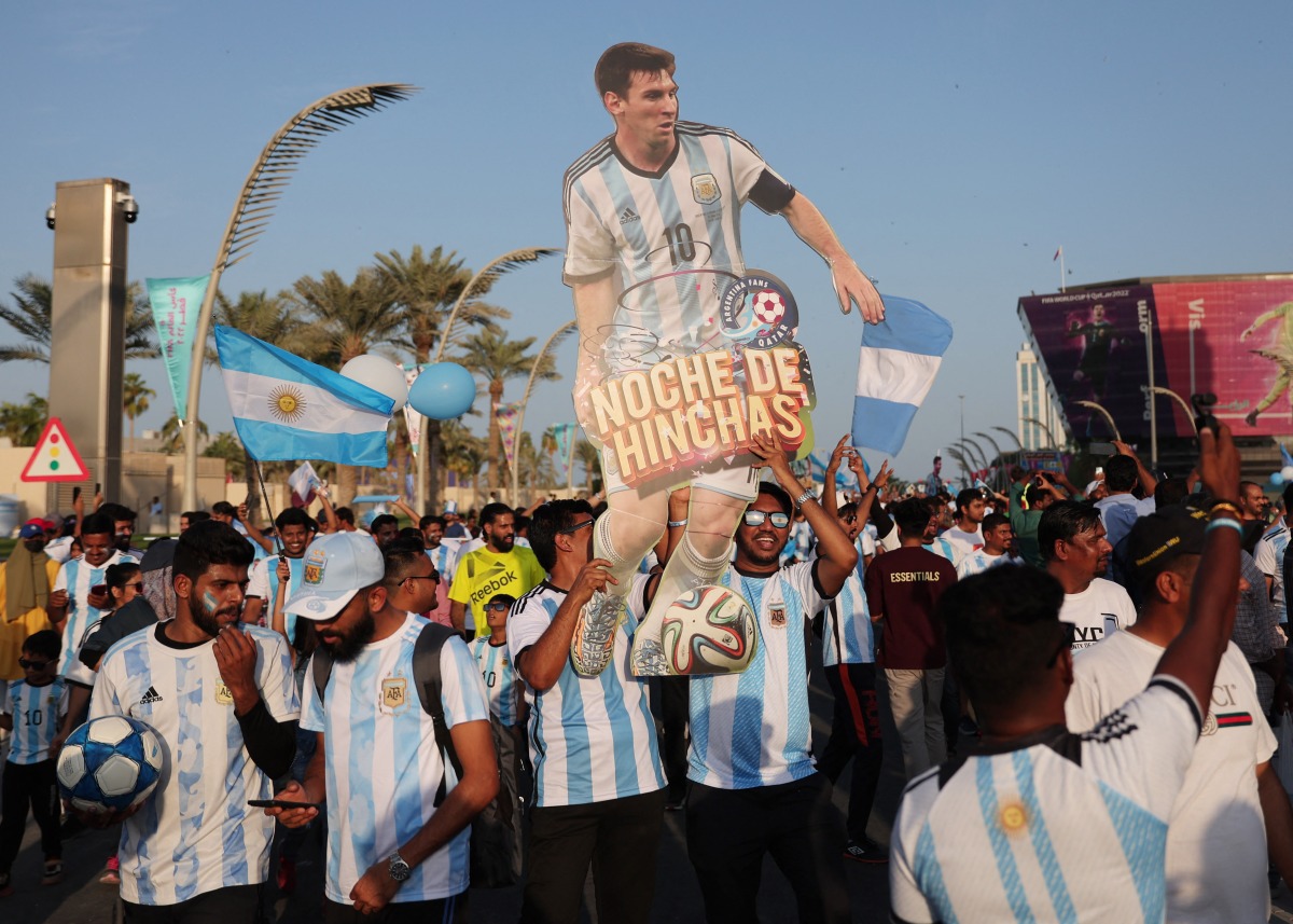 Argentina fans display a cut out of Lionel Messi during a march towards the Count Down Clock at the Doha Corniche. REUTERS