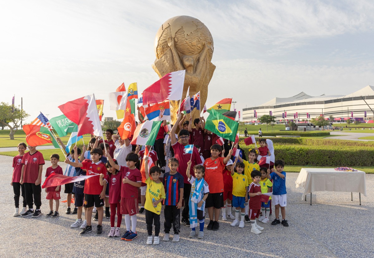 Young fans wave flags outside Al Bayt Stadium. Reuters