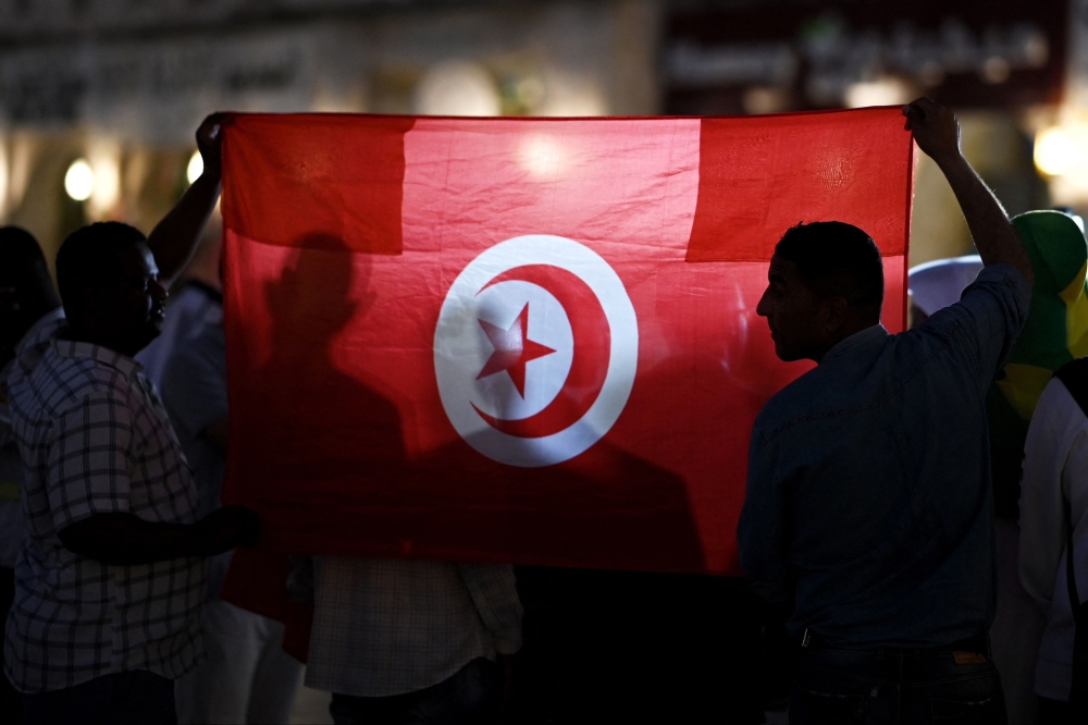 Fans of Tunisia hold up the national flag in support of the country in Doha on November 13, 2022, ahead of the Qatar 2022 World Cup football tournament. (Photo by Gabriel Bouys / AFP)