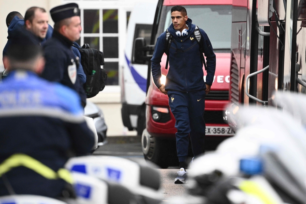 France's national football team defender Raphael Varane (centre) arrives at Le Bourget airport near Paris, on November 16, 2022, upon the team's departure for the 2022 FIFA World Cup in Qatar. (Photo by Christophe ARCHAMBAULT / AFP)