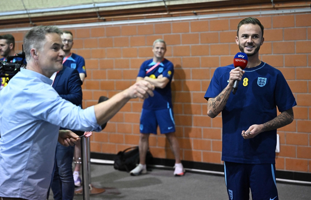 England's midfielder James Maddison (R) takes on a journalist at darts during a media session at the Al Wakrah Stadium in Doha on November 16, 2022, ahead of the Qatar 2022 World Cup football tournament. (Photo by Paul ELLIS / AFP)
 