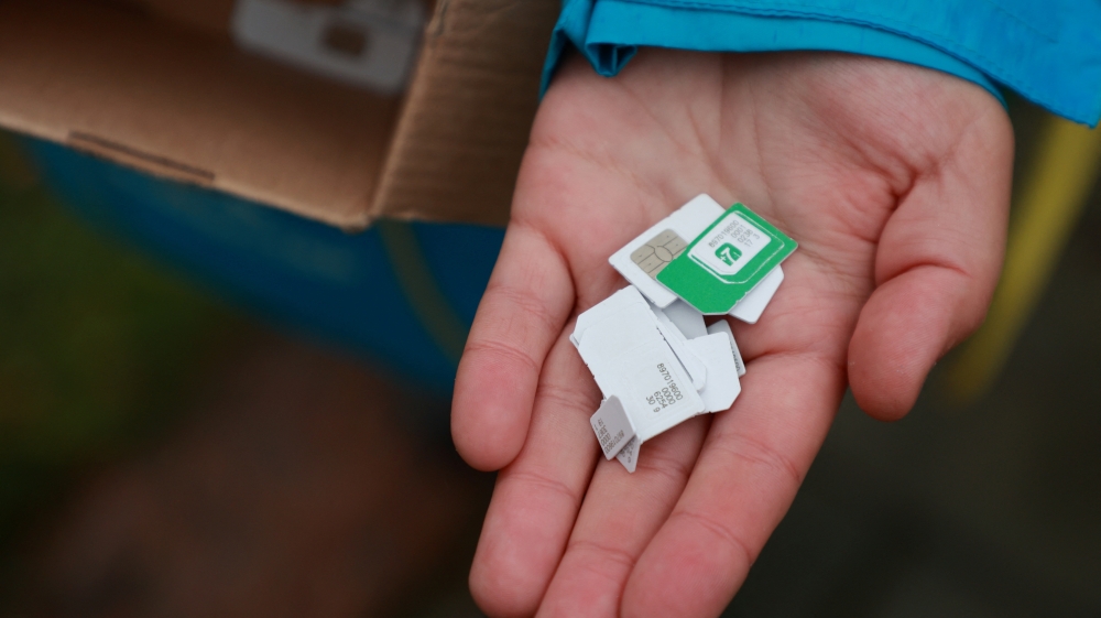 A local employee of Ukrainian telecom provider Kyivstar shows a handful of Russian SIM cards discarded by local residents after they switched to Ukrainian SIM cards in Kherson, Ukraine, on November 17, 2022. REUTERS/Joseph Campbell