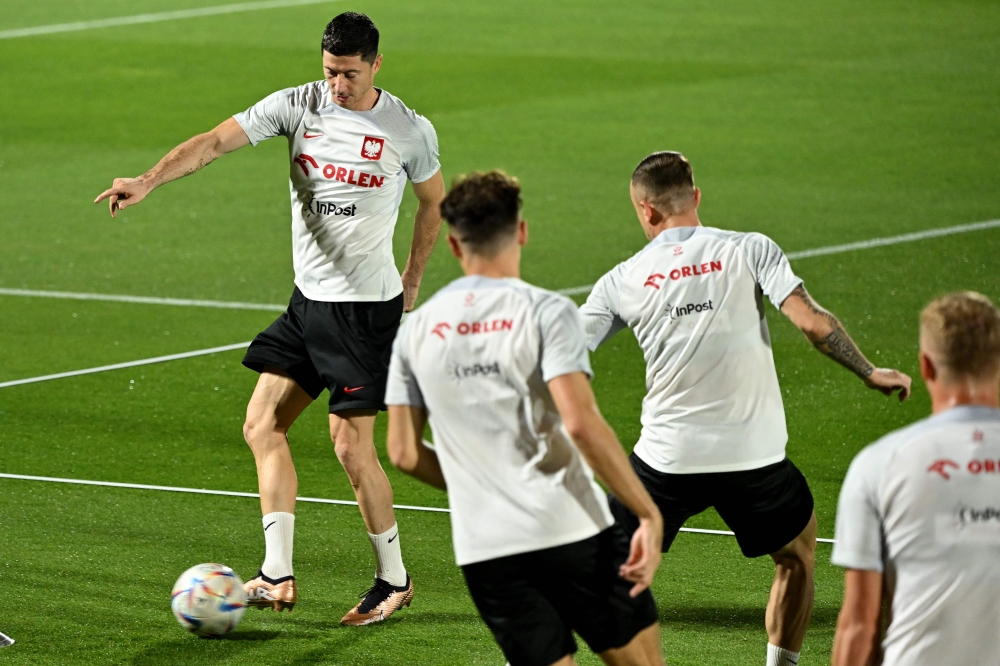 Poland's forward Robert Lewandowski (left) controls the ball during a training session at the Al Kharaitiyat SC in Doha on November 18, 2022, ahead of the Qatar 2022 World Cup football tournament. (Photo by ANDREJ ISAKOVIC / AFP)