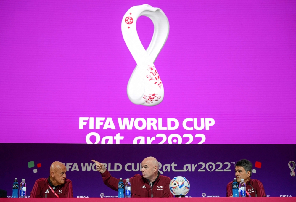 (From left) FIFA referees committee chairman Pierluigi Collina, FIFA President Gianni Infantino and head of the FIFA Referee Department Massimo Busacca address a press conference at the Qatar National Convention Center in Doha on November 18, 2022. (AFP/Anne-Christine Poujoulat)