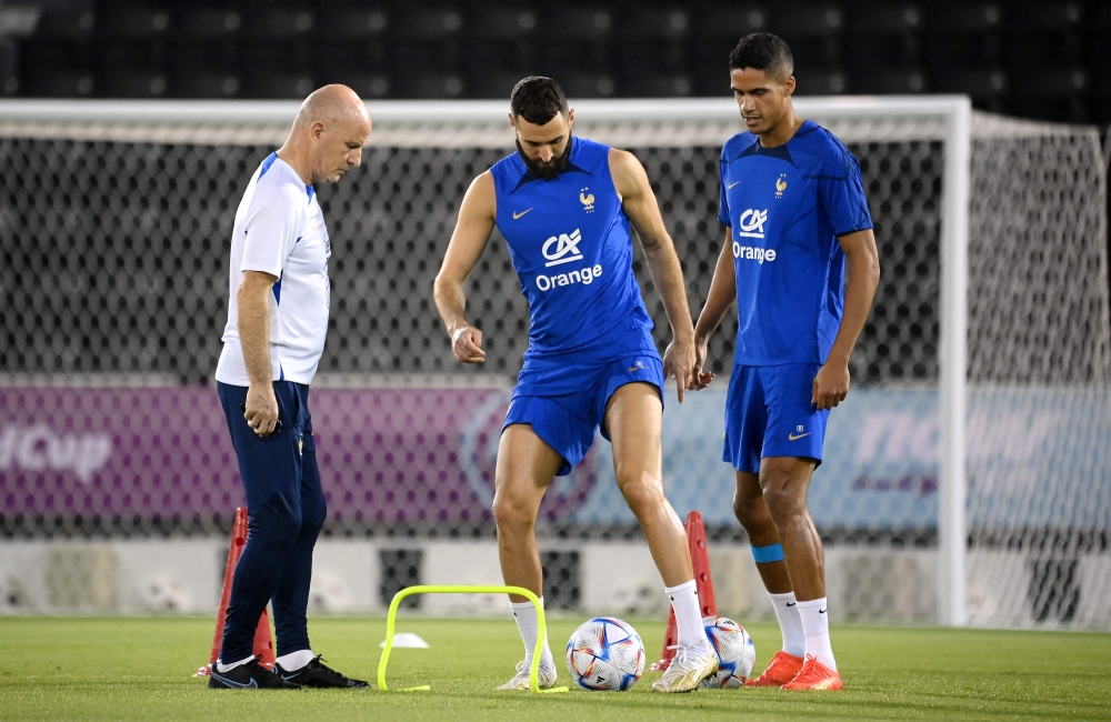 France's forward Karim Benzema (centre) and France's defender Raphael Varane takes part in a training session next to France's head coach Guy Stephan (left) at the Jassim-bin-Hamad Stadium in Doha on November 19, 2022, ahead of the Qatar 2022 World Cup football tournament. (Photo by FRANCK FIFE / AFP)
 