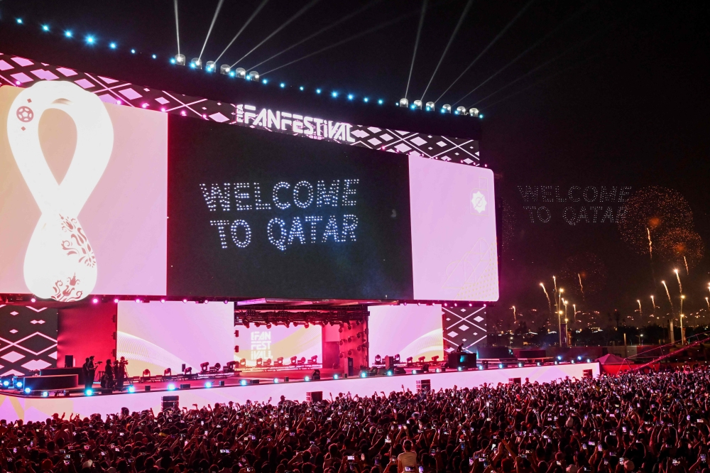 Supporters watch fireworks on a giant screen during the FIFA Fan Festival opening day at Al Bidda park in Doha on November 19, 2022, ahead of the Qatar 2022 World Cup football tournament. (Photo by Kirill Kudryavtsev / AFP)