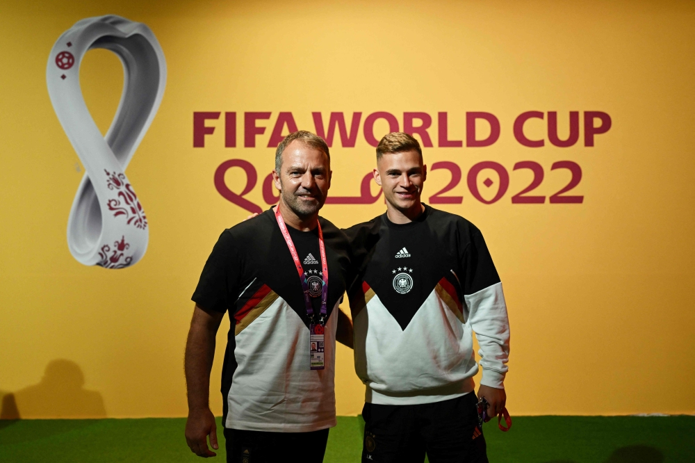 Germany's head coach Hans-Dieter Flick (left) and Germany's midfielder Joshua Kimmich pose on the green carpet ahead of a press conference at the Qatar National Convention Center (QNCC) in Doha on November 22, 2022, on the eve of the Qatar 2022 World Cup football tournament Group E match between Germany and Japan. (Photo by INA FASSBENDER / AFP)