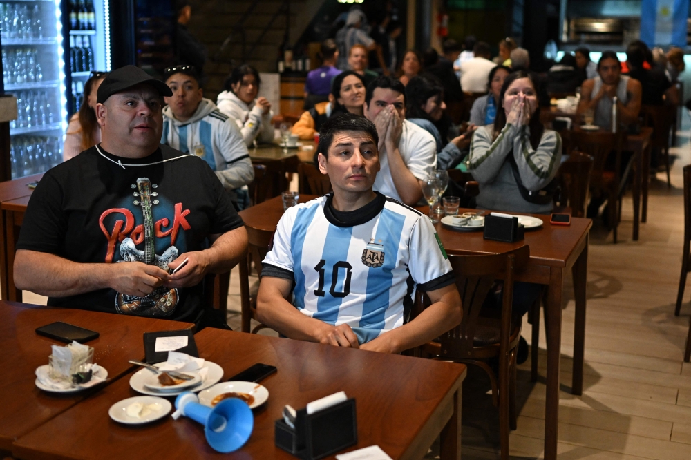 Football fans of Argentina watch the Qatar 2022 World Cup Group C football match between Argentina and Saudi Arabia on November 22, 2022 in Buenos Aires. - Saudi Arabia stunned Lionel Messi's Argentina, beating the two-time winners 2-1 in one of the biggest upsets in World Cup history. (Photo by Luis ROBAYO / AFP)