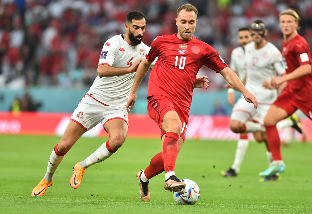 Denmark's Christian Eriksen is pursued by Tunisia's Yassine Meriah. Pic: Abdul Basit