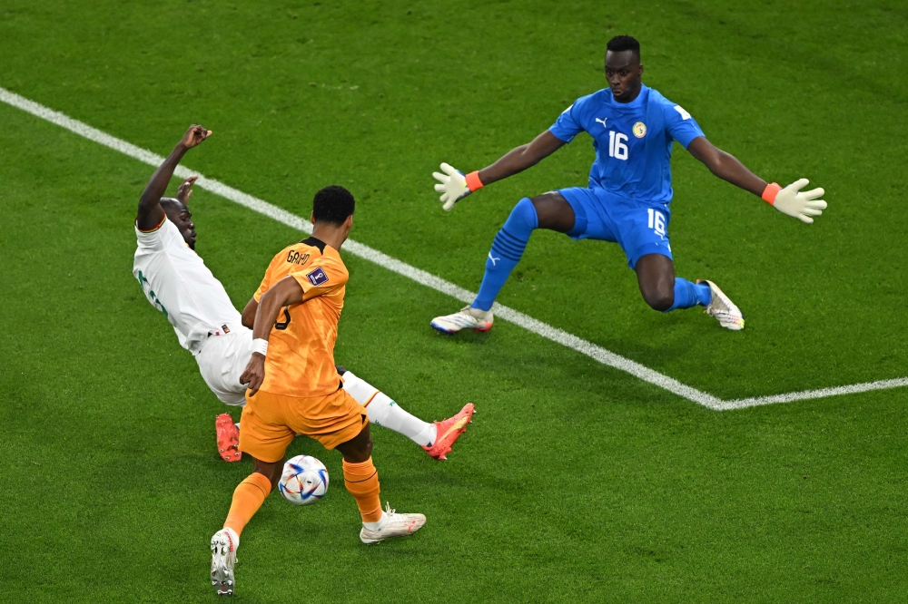 Senegal's defender #03 Kalidou Koulibaly (C) fights for the ball with Netherlands' forward #08 Cody Gakpo (C) as Senegal's goalkeeper #01 Edouard Mendy during the Qatar 2022 World Cup Group A football match between Senegal and the Netherlands at the Al-Thumama Stadium in Doha on November 21, 2022. (Photo by MANAN VATSYAYANA / AFP)