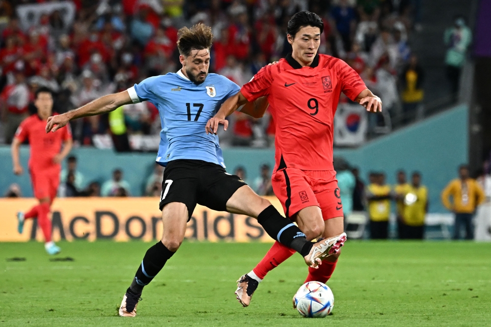 Uruguay's defender Matias Vina fights for the ball with South Korea's forward Cho Gue-sung during the Qatar 2022 World Cup Group H football match between Uruguay and South Korea at the Education City Stadium in Al-Rayyan, west of Doha on November 24, 2022. (Photo by Anne-Christine POUJOULAT / AFP)