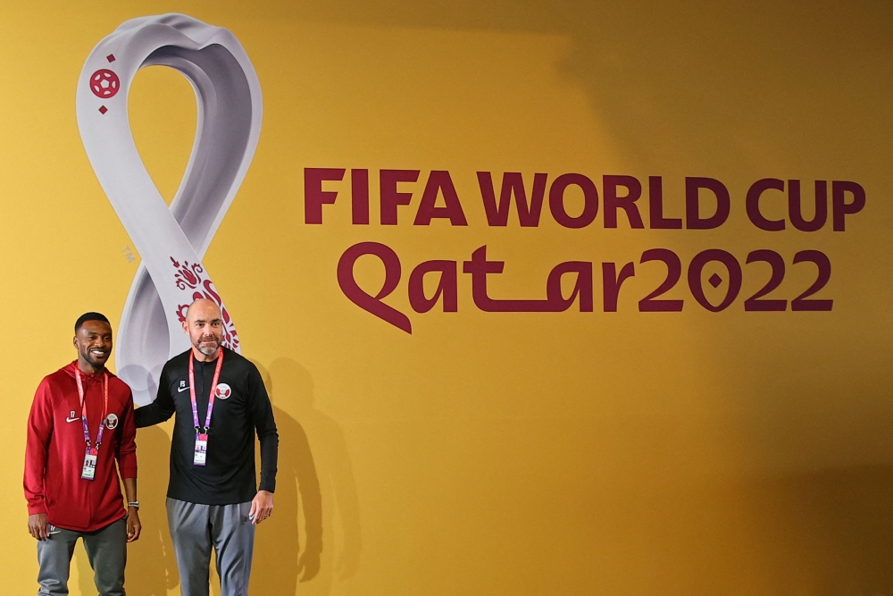 Qatar's Spanish coach Felix Sanchez (right) and Qatar's defender Ismaiel Mohammed pose for a photograph ahead of a press conference at the Qatar National Convention Center (QNCC) in Doha on November 24, 2022, on the eve of the Qatar 2022 World Cup football match between Qatar and Senegal. (Photo by KARIM JAAFAR / AFP)