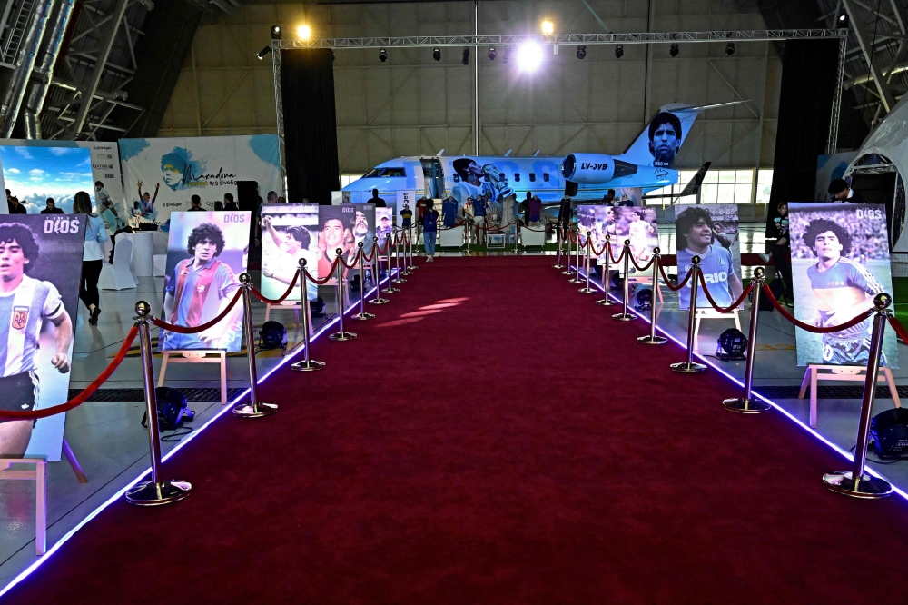 A general view of posters of Argentina's Diego Maradona on the second anniversary of his death at a fan zone devoted to the Argentine at Doha's international airport on November 25, 2022. (Photo by JAVIER SORIANO / AFP)