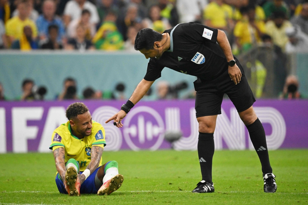 Iranian referee Alireza Faghani gestures to Brazil's forward Neymar during the Qatar 2022 World Cup Group G football match between Brazil and Serbia at the Lusail Stadium in Lusail, north of Doha, on November 24, 2022. (Photo by NELSON ALMEIDA / AFP)