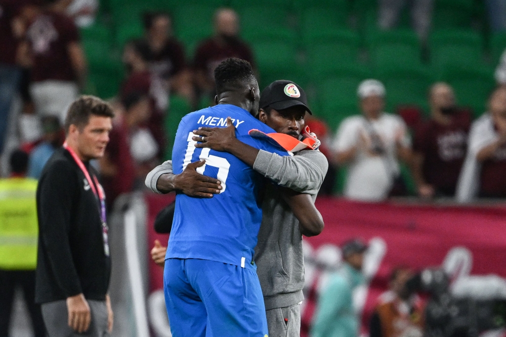 Senegal's coach Aliou Cisse and goalkeeper Edouard Mendy embrace after the final whistle of the Qatar 2022 World Cup Group A football match between Qatar and Senegal at the Al Thumama Stadium on November 25, 2022. (Photo by OZAN KOSE / AFP)