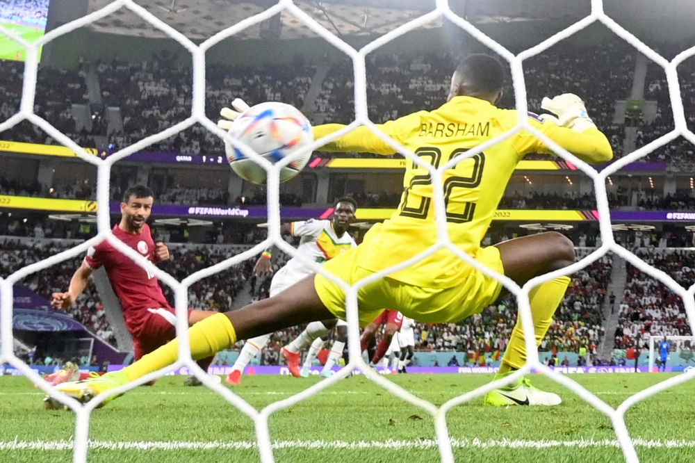 Senegal's Bamba Dieng scores his team's third goal during the Qatar 2022 World Cup Group A football match between Qatar and Senegal at the Al Thumama Stadium on November 25, 2022. (Photo by Odd Andersen / AFP)